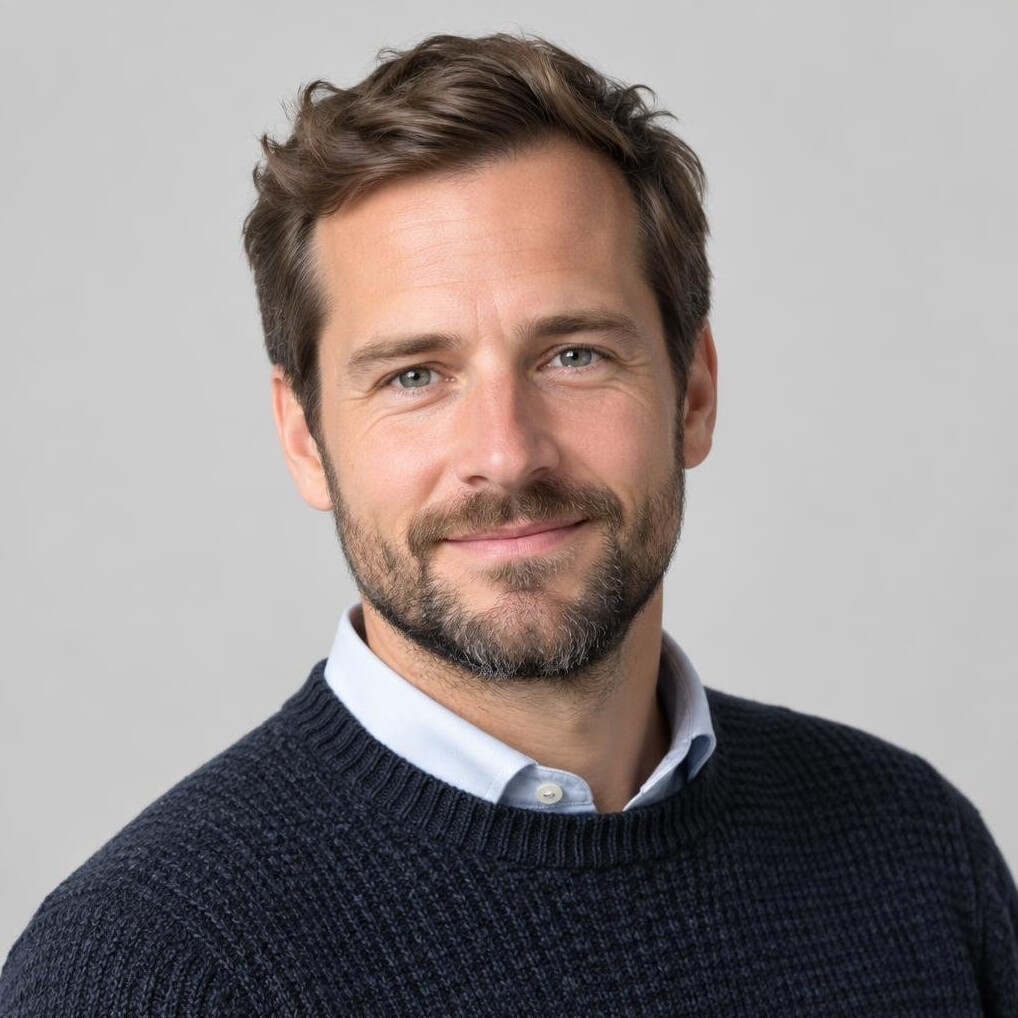 Studio portrait of a bearded man in a sweater