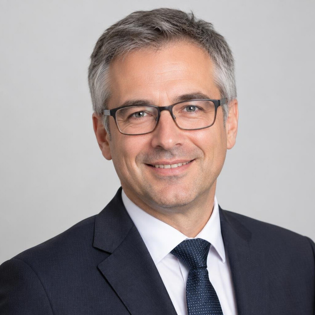 Studio portrait of a man with glasses in a suit